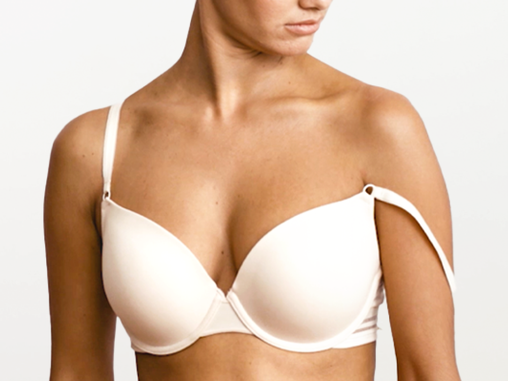 Woman wearing a beige bra against a plain background