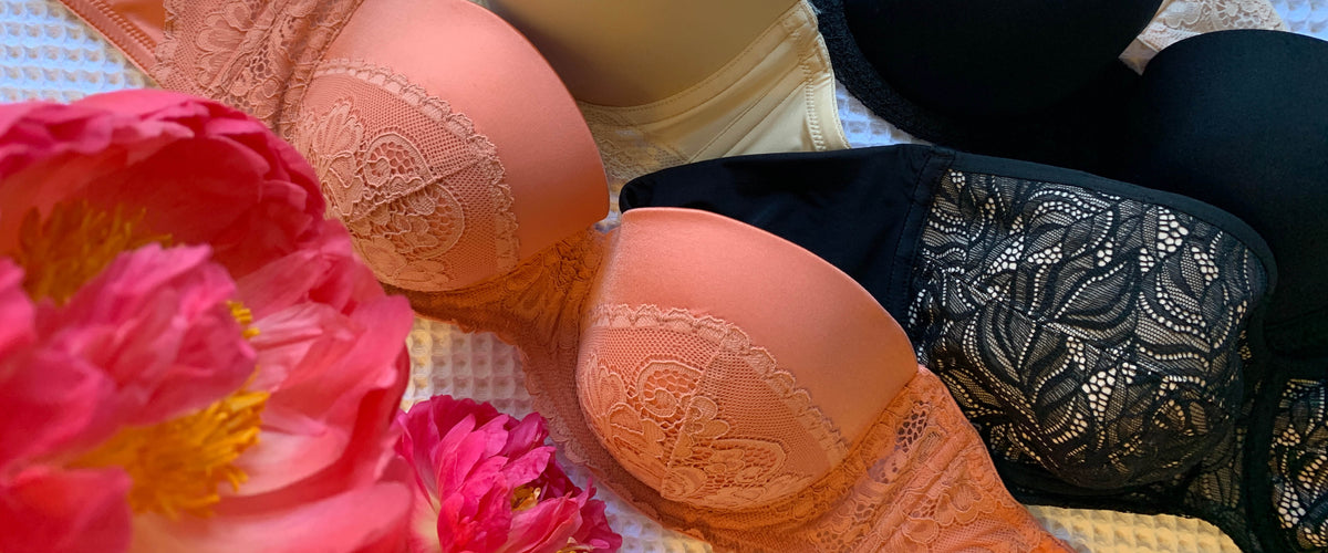 Assorted colour strapless bras shown as a flatlay with flowers