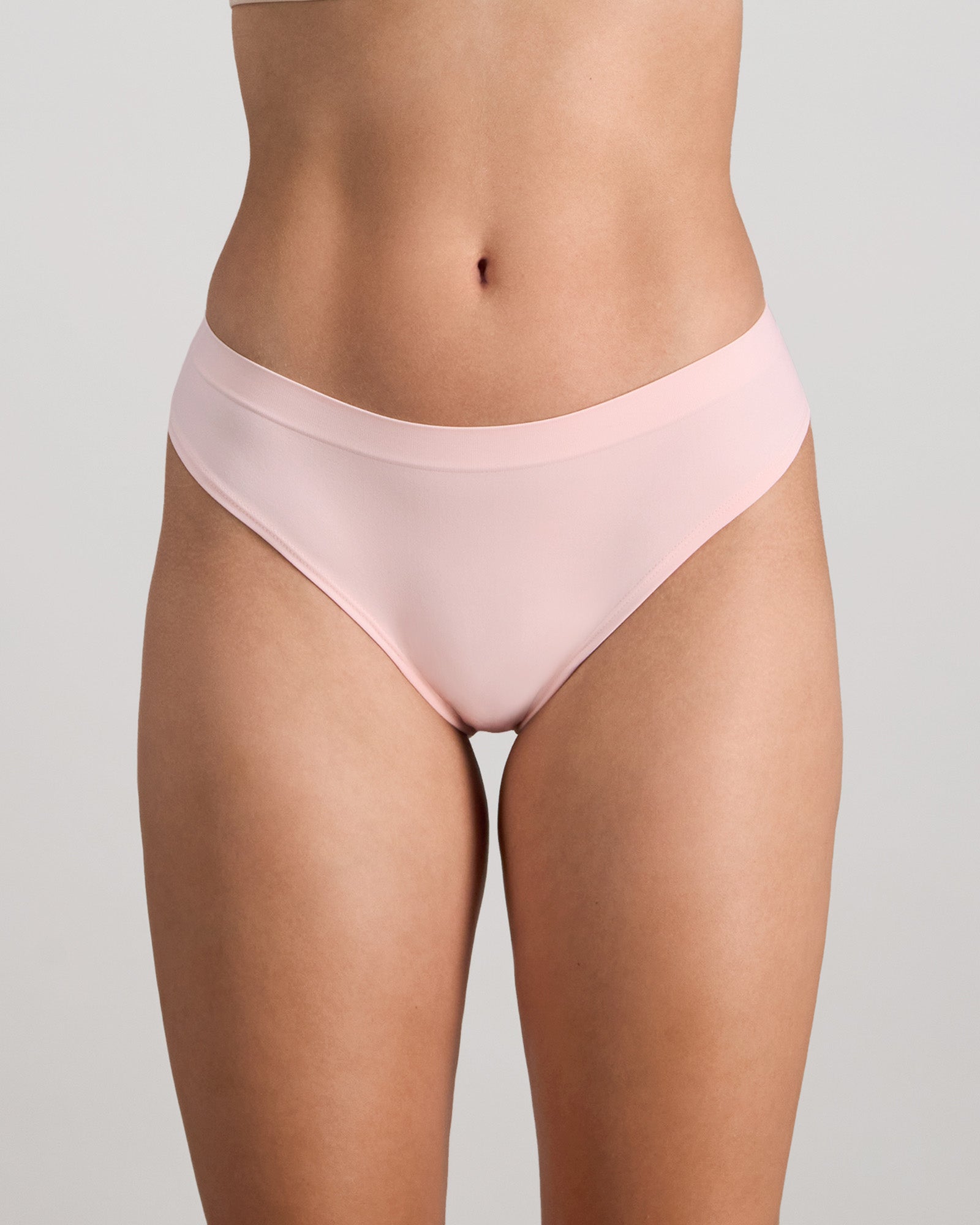Model wears Seamless Soft Thong in ICY PINK. On body front view