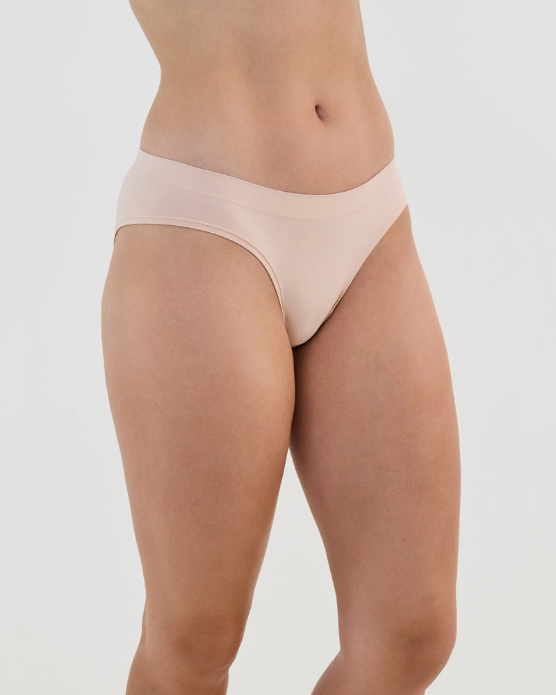 Model wears Seamless Soft Bikini in LATTE. On body side view