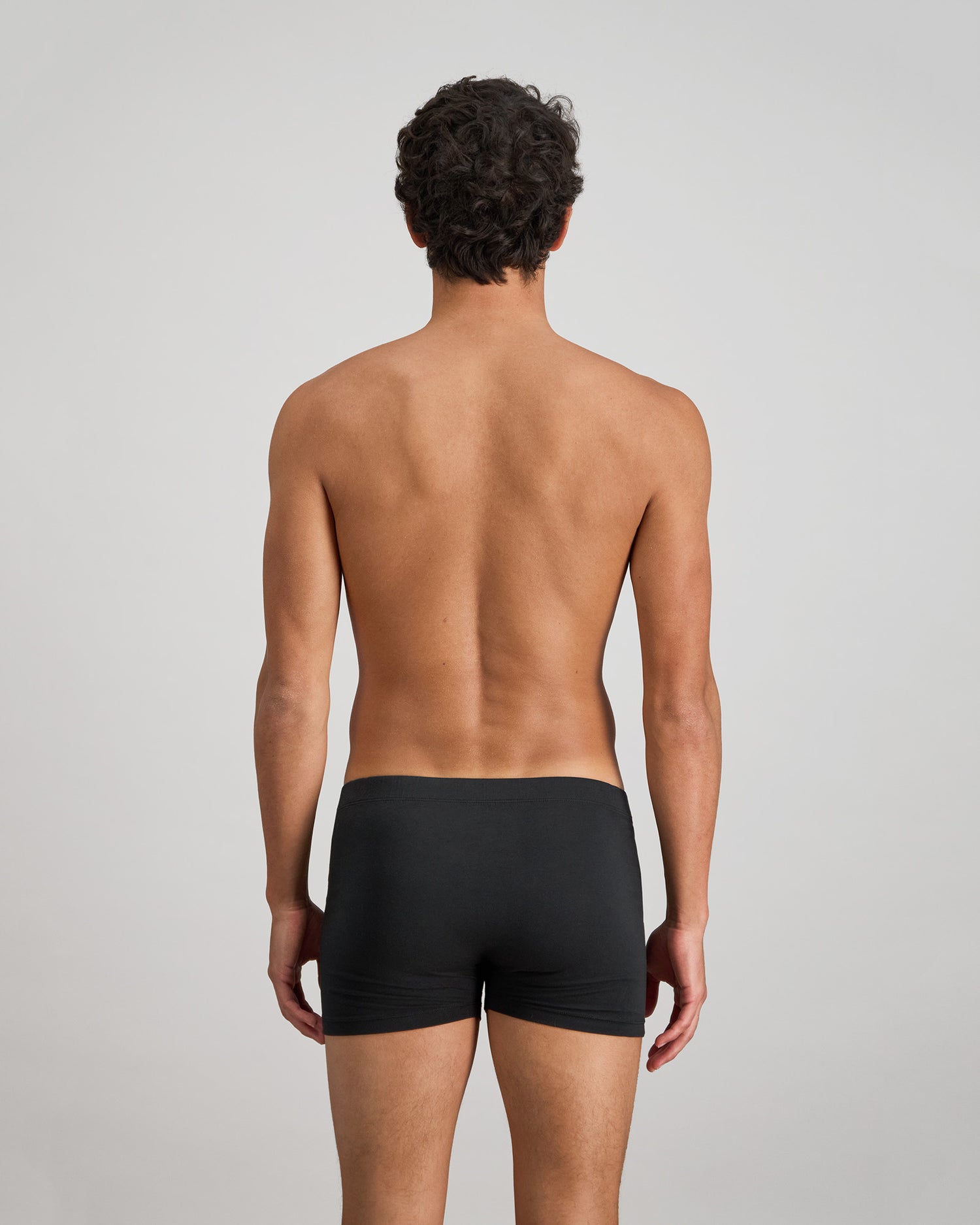 Model wears Cotton Stretch Mens Trunk in BLACK. On body back view