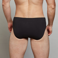 Model wears Cotton Stretch Mens Brief in BLACK. On body back view