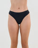 Model wears Seamless Soft Thong in BLACK. On body front view