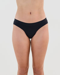 Model wears Seamless Soft Bikini in BLACK. On body front view