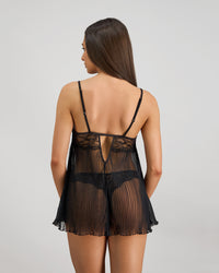 Model wears Oasis Glow Babydoll in BLACK. On body back view
