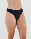 Model wears Seamless Soft Thong in BLACK. On body side view