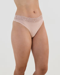 Model wears Cotton And Lace Thong in LATTE. On body side view