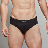 Model wears Cotton Stretch Mens Brief in BLACK. On body front view