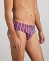 Model wears Cotton Stretch Mens Brief in TIBETAN RED STRIPE. On body side view