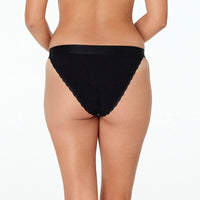 Model wears Cotton Logo Tanga in BLACK. On body back view