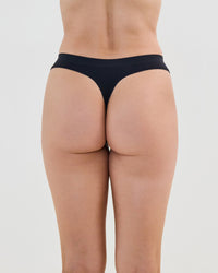 Model wears Seamless Soft Thong in BLACK. On body back view