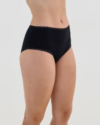 Model wears Stretch Cotton Full Brief in BLACK. On body side view