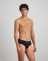 Model wears Cotton Texture Mens Brief in BLACK. On body side view