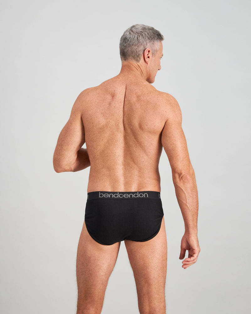 Model wears Cotton Texture Mens Brief in BLACK. On body back view