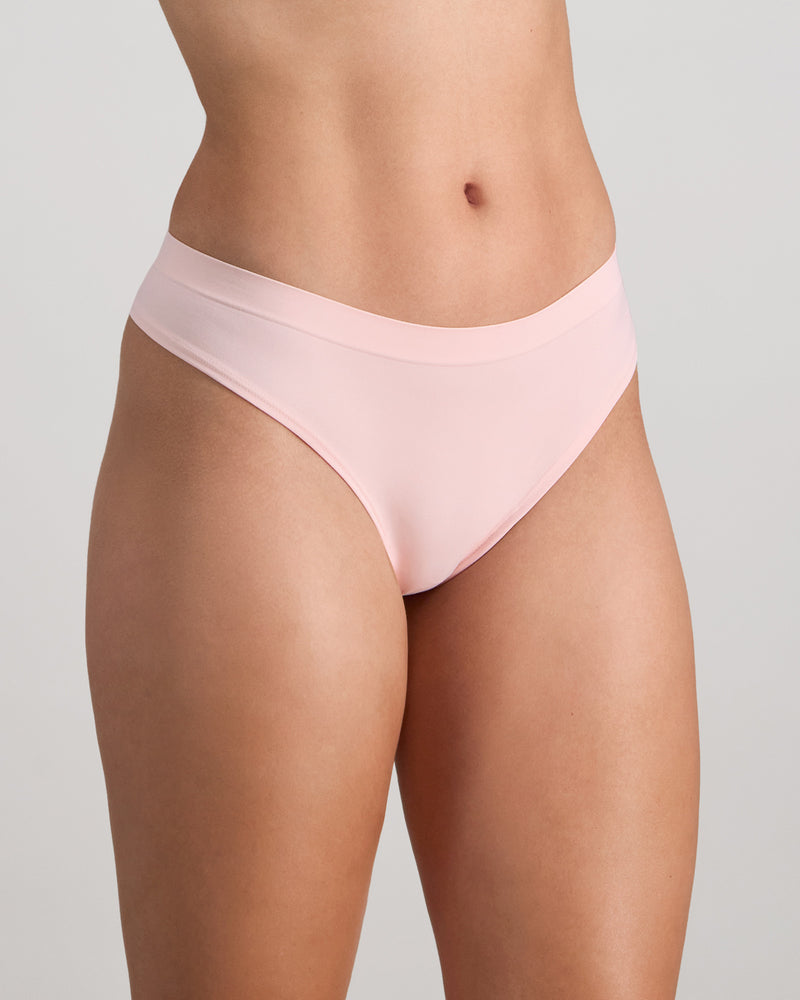Model wears Seamless Soft Thong in ICY PINK. On body side view