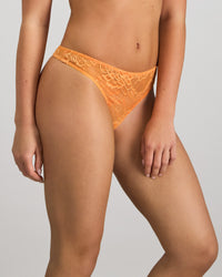 Model wears My Fit Underlayer Thong in TANGERINE. On body side view