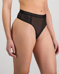 Model wears Sheer Essence Thong in BLACK. On body side view