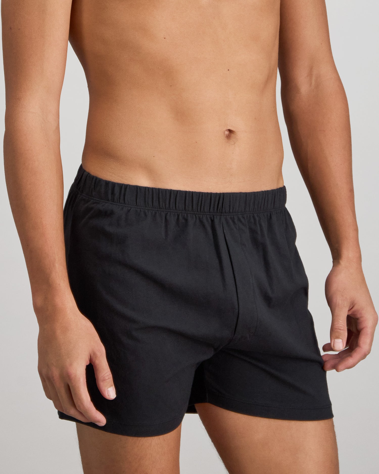 Model wears Cotton Basics Mens Trunk in BLACK. On body side view