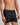 Model wears Cotton Basics Mens Trunk in BLACK. On body side view