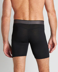 Model wears Everyday Active Mens Long Trunk in BLACK. On body back view