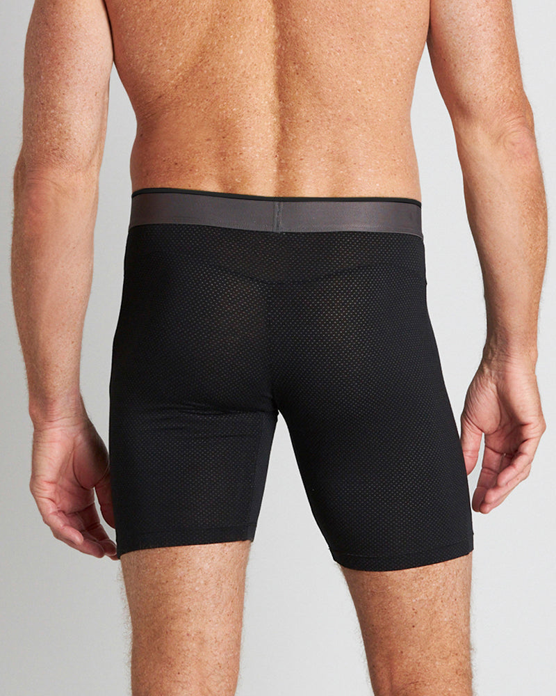 Model wears Everyday Active Mens Long Trunk in BLACK. On body back view