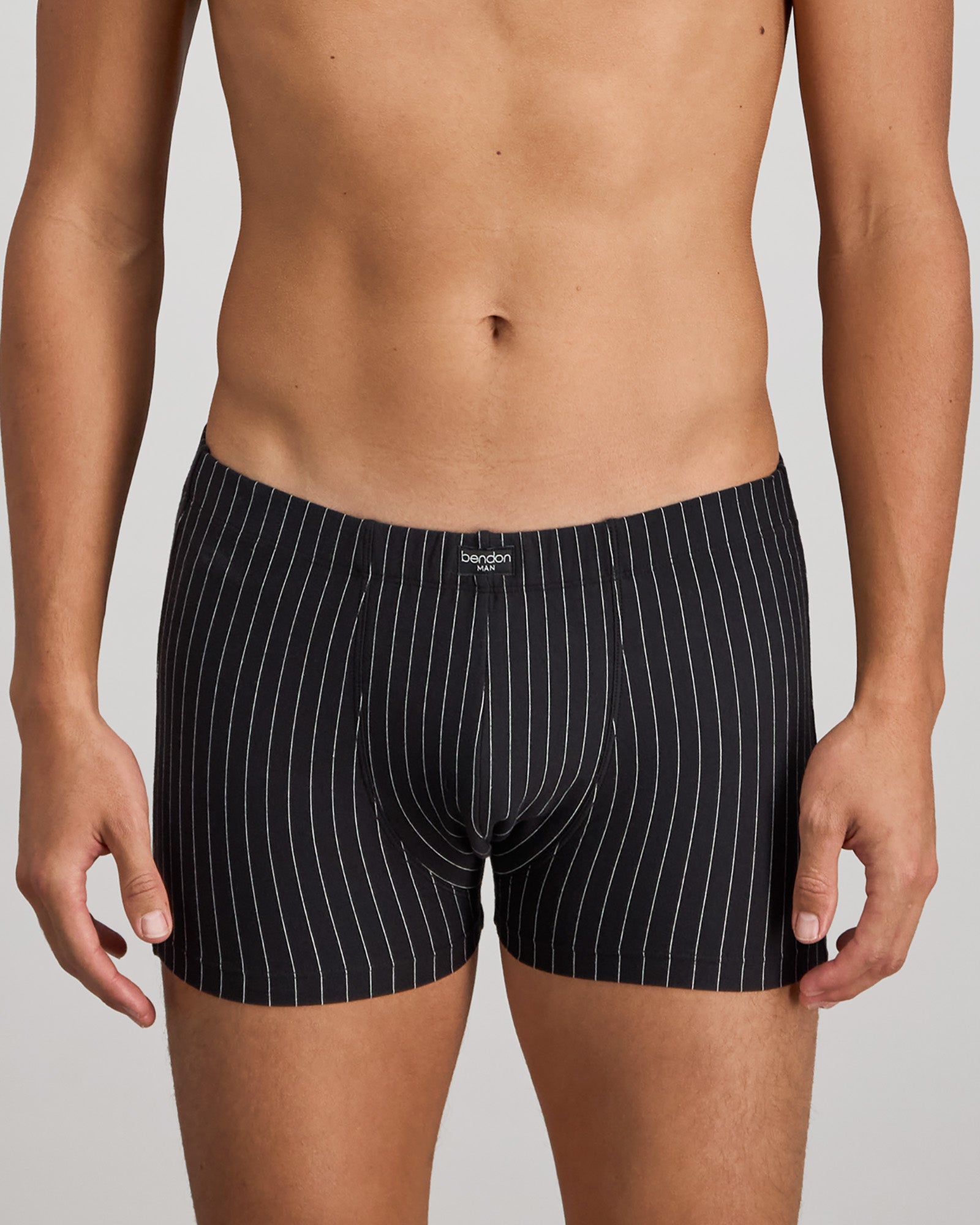 Model wears Cotton Stretch Mens Trunk in BLACK PINSTRIPE. On body front view