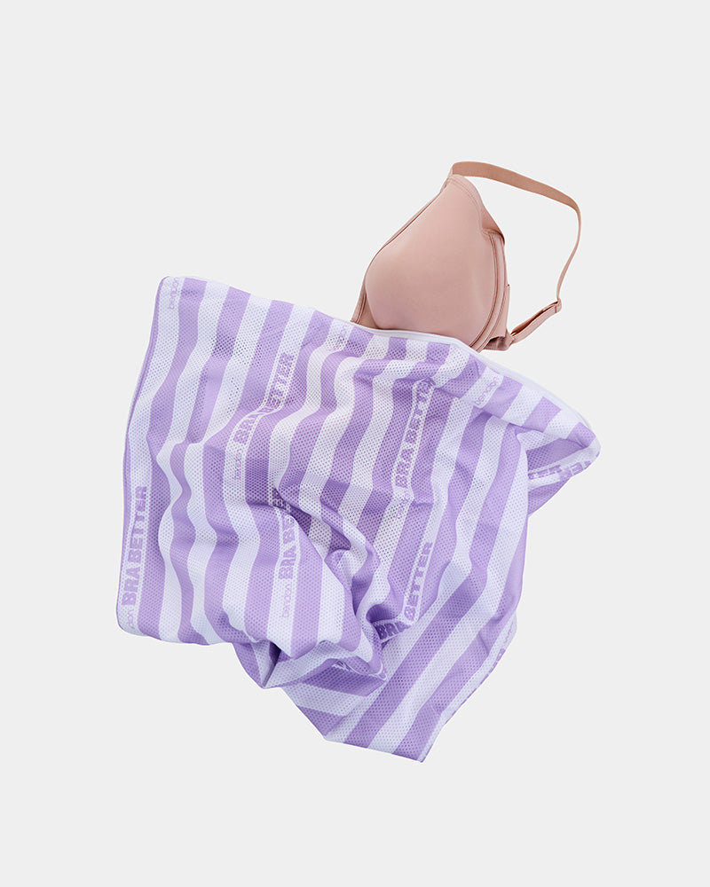 Model wears BB Stripe Wash Bag in STRIPE. On body side view