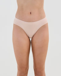 Model wears Seamless Soft Bikini in LATTE. On body front view