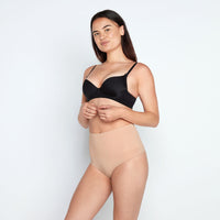 Model wears Medium Control Thong in CARAMEL. On body front view