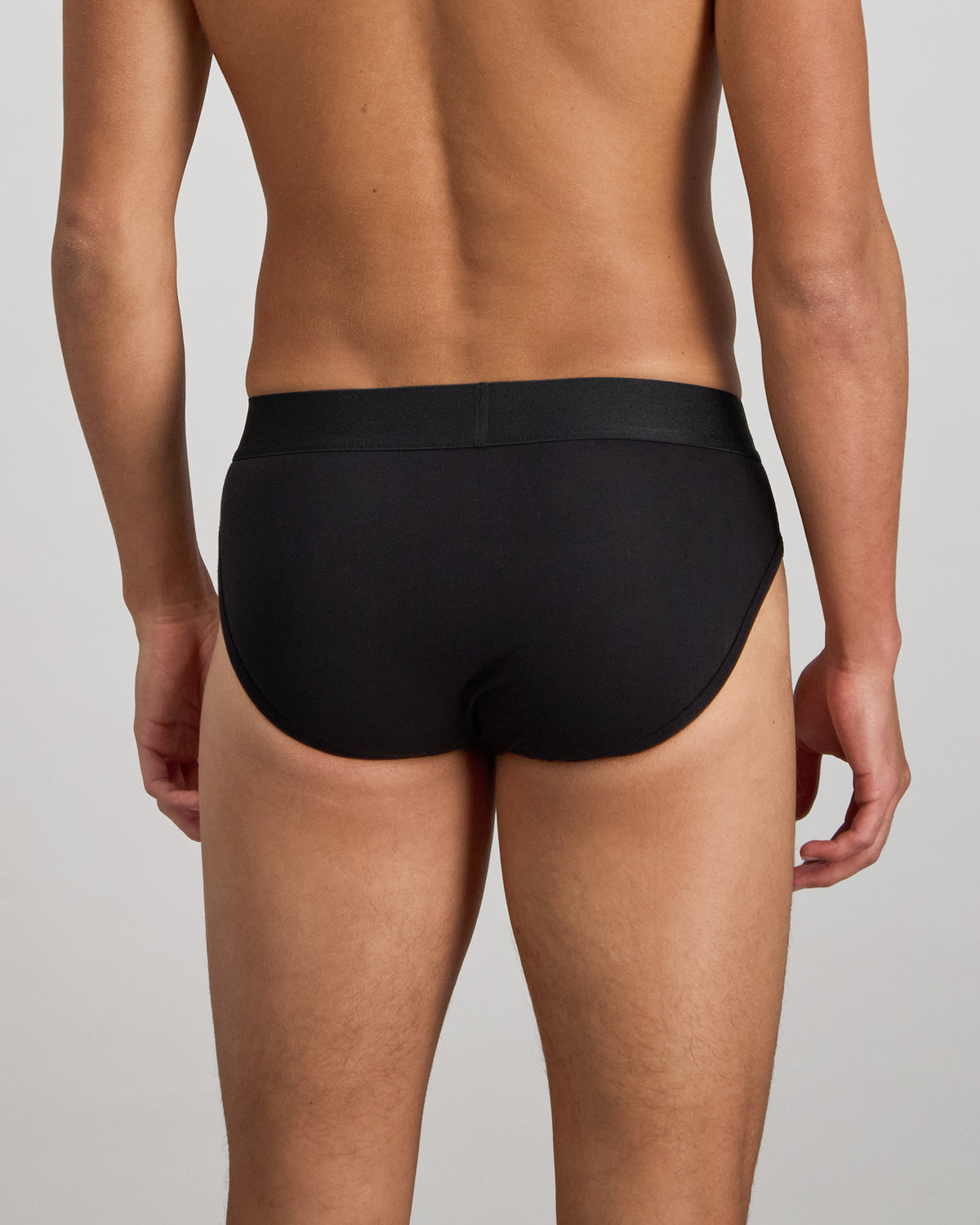 Model wears Bamboo Mens Brief in BLACK. On body back view