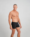 Model wears Cotton Stretch Mens Trunk in BLACK. On body side view