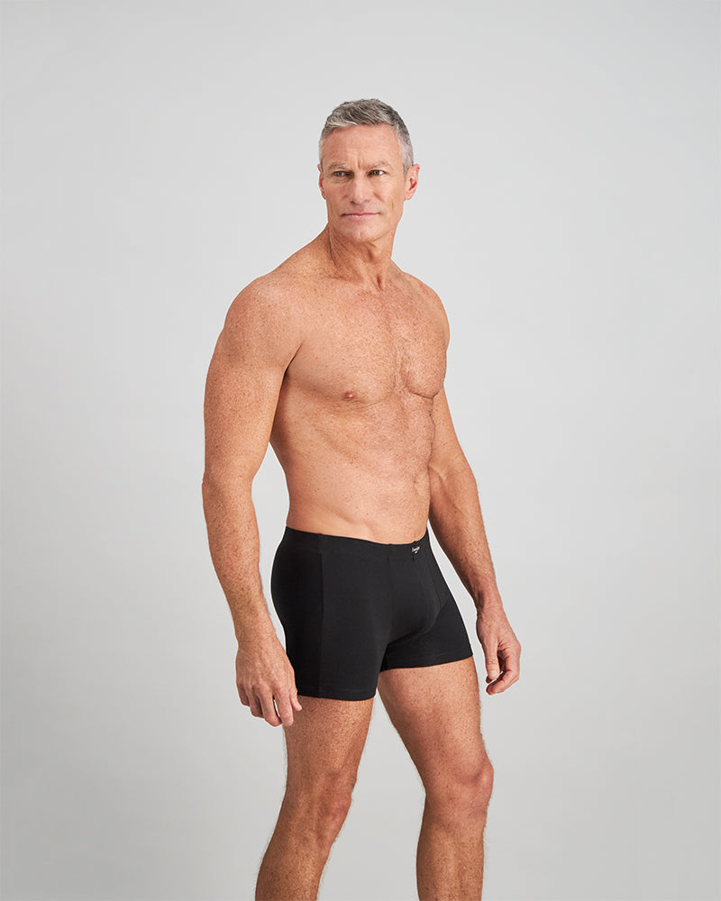 Model wears Cotton Stretch Mens Trunk in BLACK. On body side view