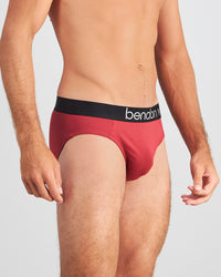 Model wears Everyday Essential Mens Brief in TIBETAN RED. On body side view