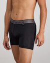 Model wears Everyday Active Mens Long Trunk in BLACK. On body side view
