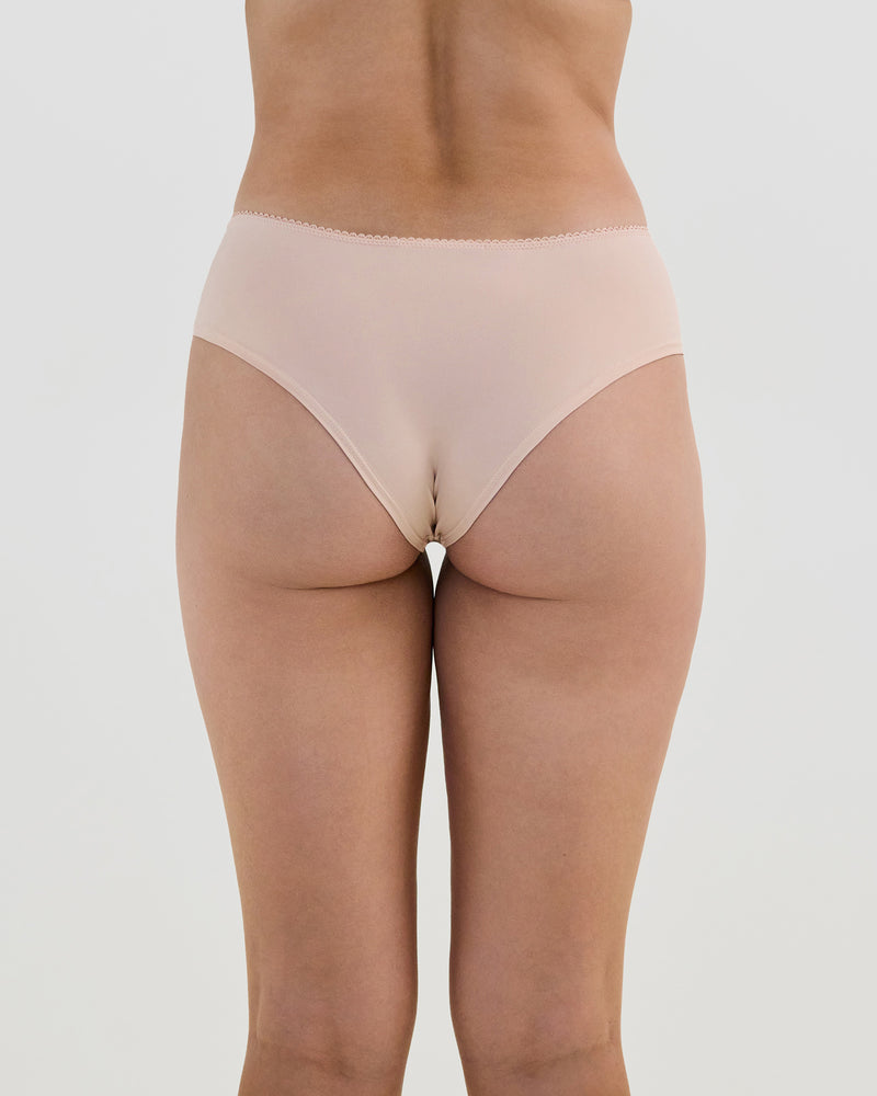 Model wears Lacey Brazilian in LATTE. On body back view