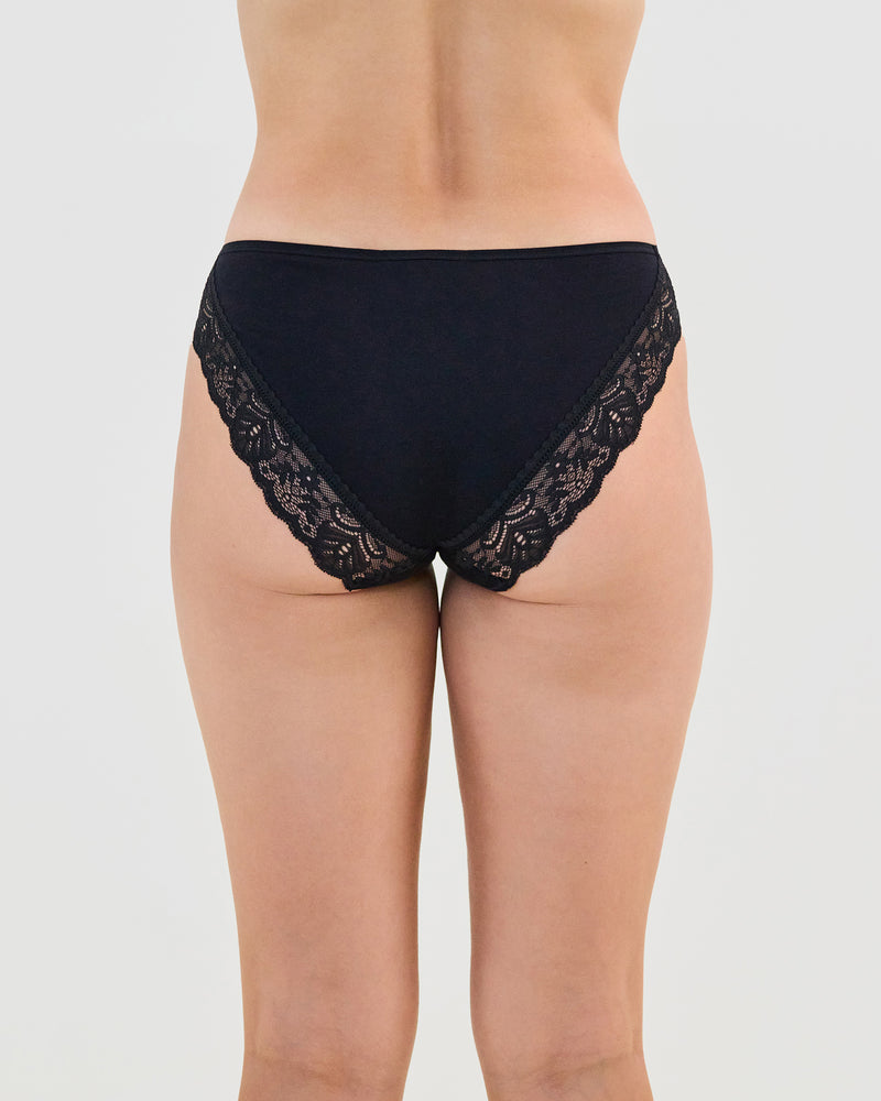 Model wears Cotton And Lace Bikini in BLACK. On body back view