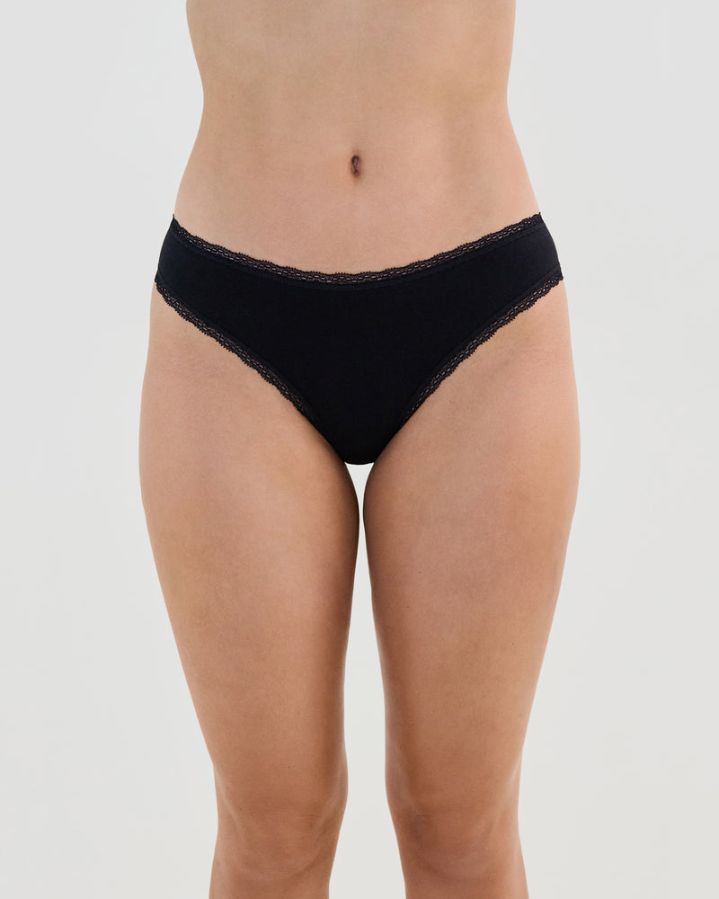 Model wears Stretch Cotton Bikini in BLACK. On body front view