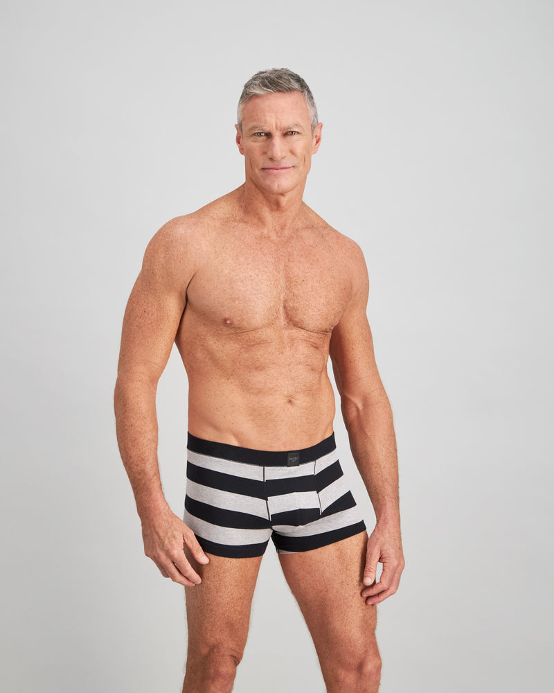 Model wears Rugby Stripe Mens Trunk in BLACK RUGBY STRIPE. On body side view