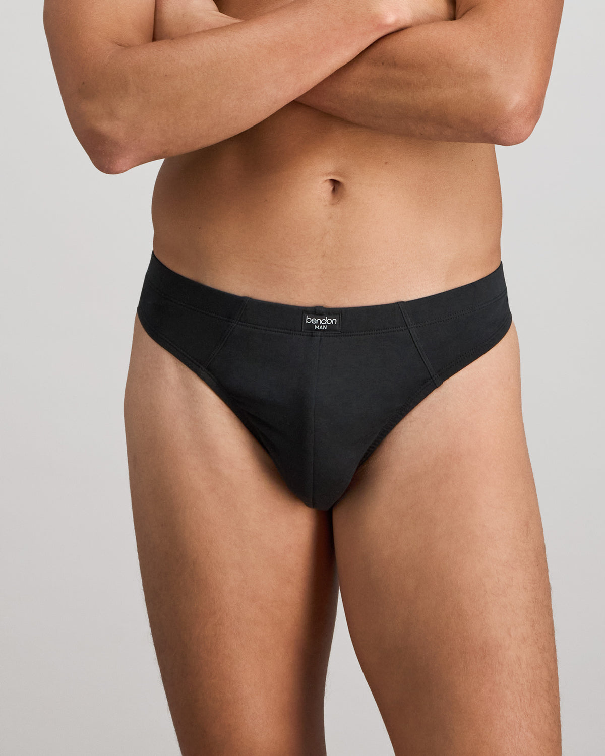 Model wears Cotton Stretch Mens Thong in BLACK. On body front view