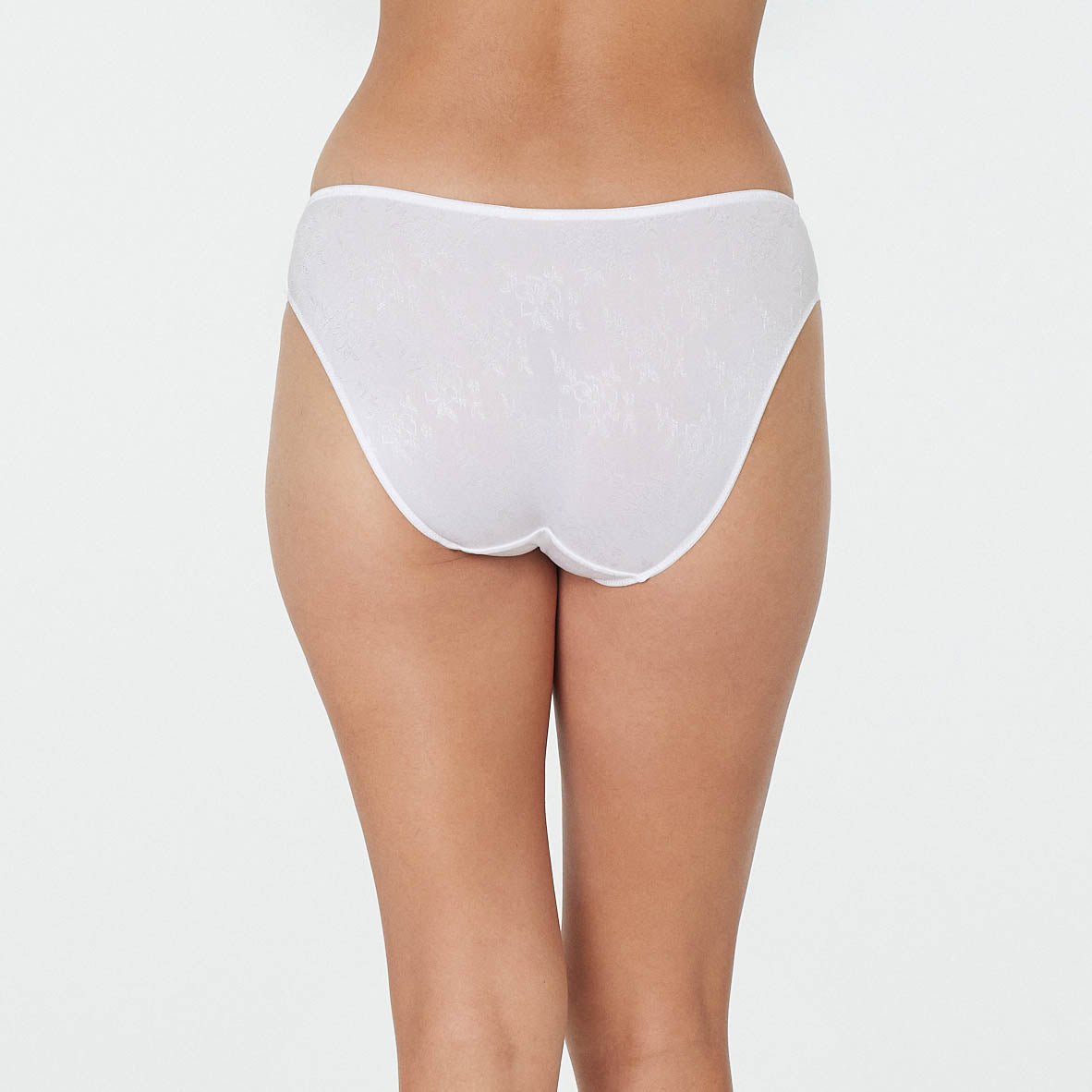 Model wears Body Lace High Cut Brief in WHITE. On body back view