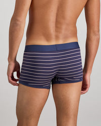 Model wears Bold Stripe Mens Trunk in PEACOAT/PLUM STRIPE. On body back view