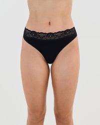 Model wears Cotton And Lace Thong in BLACK. On body front view