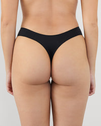 Model wears Au Naturel Thong in BLACK. On body back view