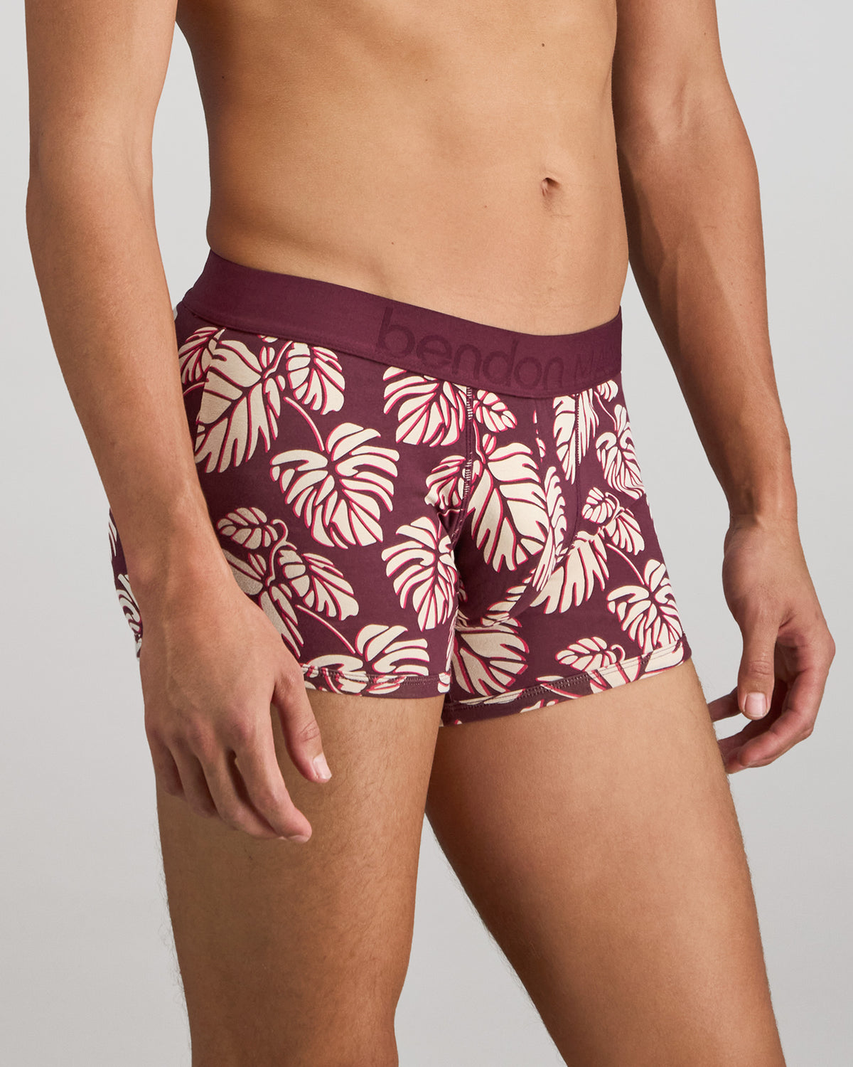 Model wears Retros Print Mens Trunk in FIG MONSTERA PRINT. On body side view