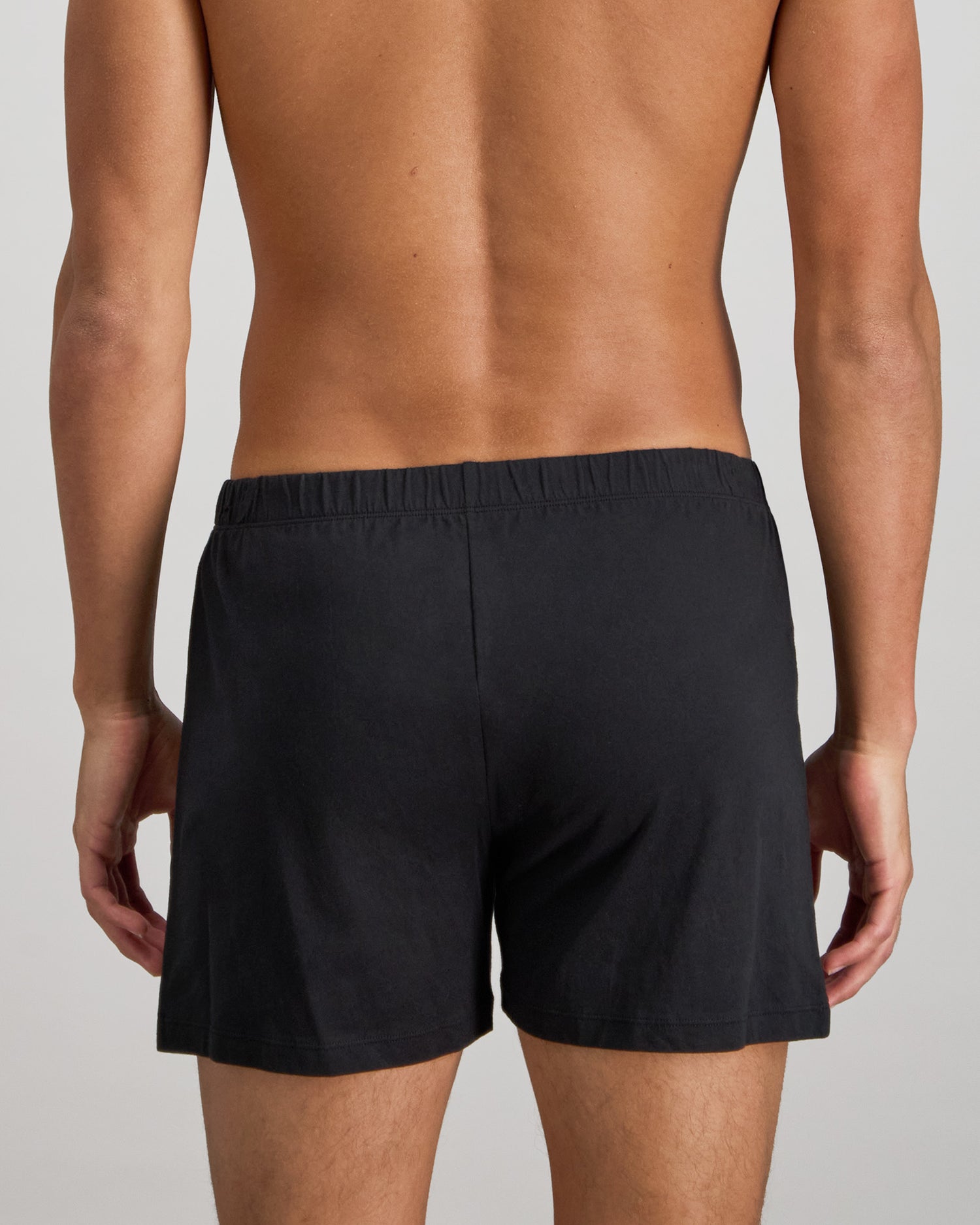Model wears Cotton Basics Mens Trunk in BLACK. On body back view