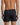 Model wears Cotton Basics Mens Trunk in BLACK. On body back view