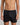 Model wears Cotton Basics Mens Trunk in BLACK. On body front view