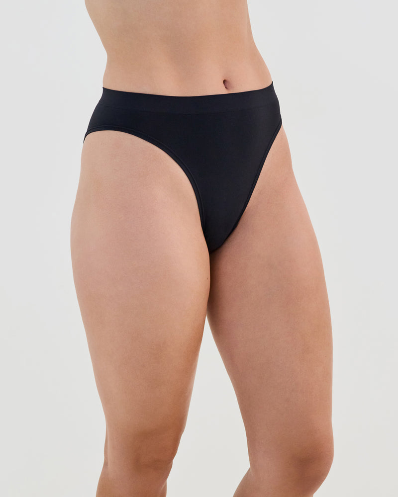 Model wears Seamless Soft High Cut Brief in BLACK. On body side view