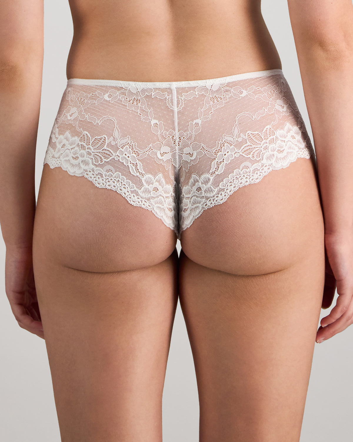 Model wears My Fit Lace Brazilian in WHITE. On body back view