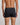 Model wears Cotton Classics Mens Trunk in BLACK. On body back view